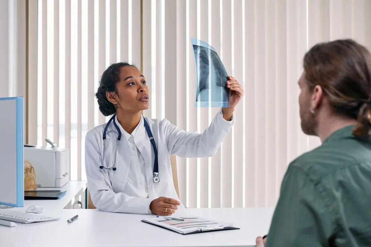 Médica mostrando uma radiografia ao paciente durante a consulta