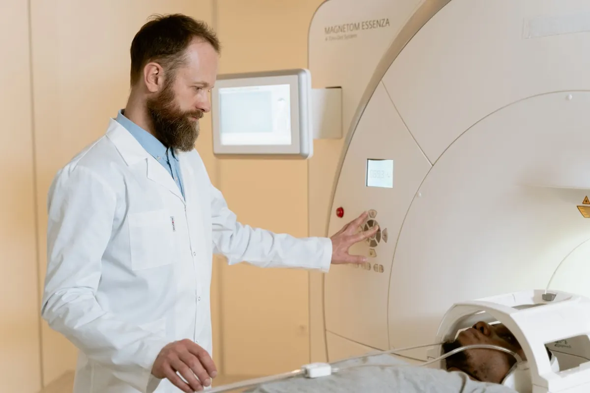 Médico preparando o aparelho de ressonância magnética com o paciente deitado para o exame